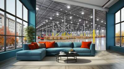 Interior of large warehouse industrial building with parked forklifts, shipping containers, and crates Wall mural