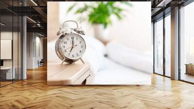 Alarm clock morning wake-up time on bedside table background Wall mural