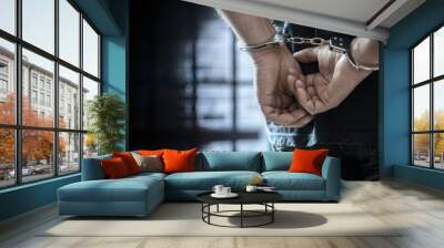 Criminal wearing handcuffs in prison Wall mural