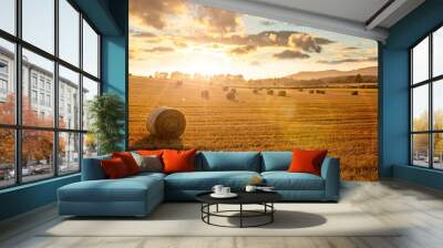 Hay bales in golden field with sunset summer background Wall mural