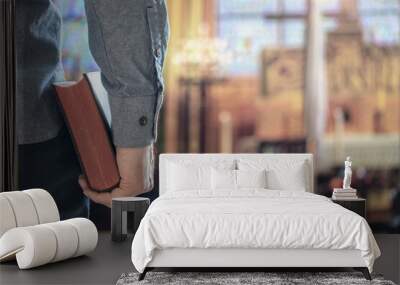 Man holding holy bible in church with alter in background Wall mural