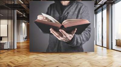 Man holding reading holy bible with gray background Wall mural