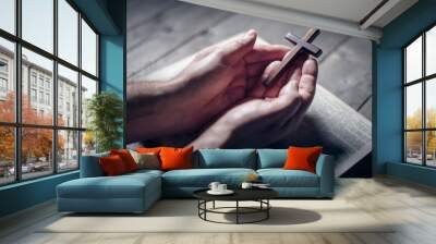 Praying with the bible and holding religious crucifix cross Wall mural