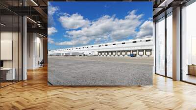 Rear view of large white distribution warehouse industrial building with parking lot Wall mural