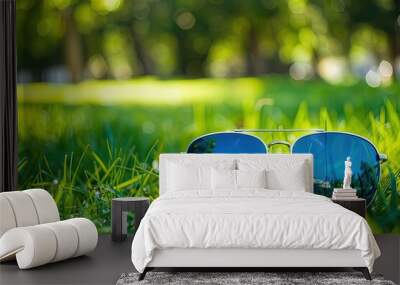 Sunglasses in the green grass outdoors in a field in the afternoon daylight Wall mural