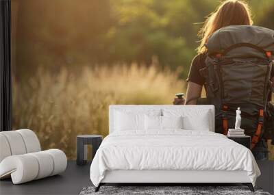 woman in her 20s with a backpackers pack on her back with a walking stick walking towards adventure  Wall mural