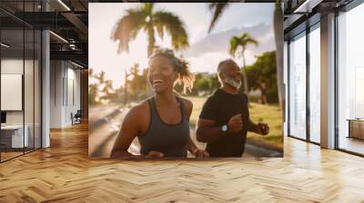 A black woman and a man are running together in a park. They are both smiling and enjoying their time Wall mural