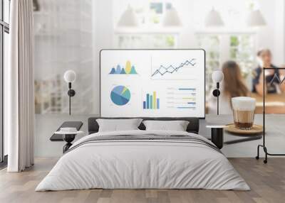 Laptop on wooden table showing charts and graph Wall mural