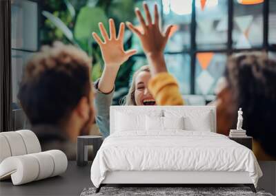 Young business team celebrates success joyfully, Three people are smiling and giving each other high fives. Scene is happy and celebratory Wall mural