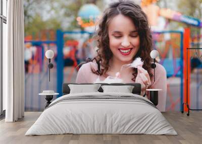 Close up portrait of a happy smiling excited girl holding cotton candy at amusement park Wall mural