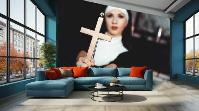 Nun holding a cross. The concept of religion. Young beautiful nun expels the devil Wall mural