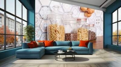 Pasta in glass jars. Pasta on a wooden countertop in a modern bright kitchen. Wall mural