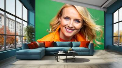 Blond Woman Smiling in Orange Jacket Against Green Background, portrait, woman, green screen Wall mural