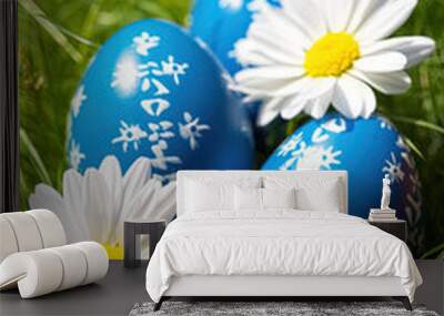 Blue Easter eggs with a print of daisies lie in the green grass Wall mural