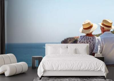 Senior couple relaxing together near the sea on sunny day Wall mural