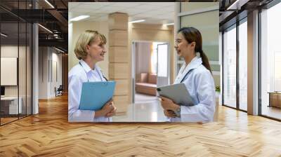 Portrait shot of doctors taking in positive emotion wearing white medical gown and standing with confident insider of the hospital. Healthcare expertise, professional service. Wall mural