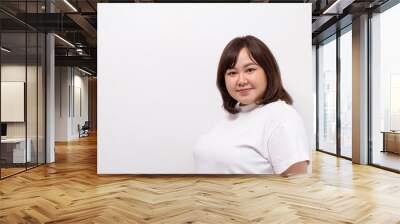 Young beautiful Asian oversize women smile with positive emotion, feeling happy and proud with her body size. Portrait shot on white background with copy space. Wall mural