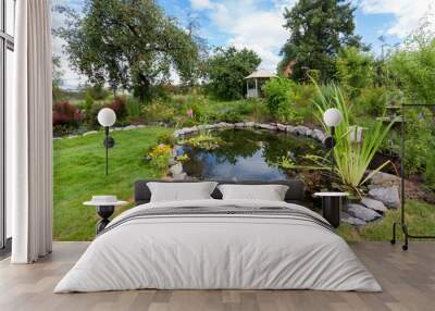 Beautiful designed garden fish pond with water-lily in a well cared backyard gardening background Wall mural