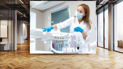 Dentist assistant wipes dental equipment in office Wall mural