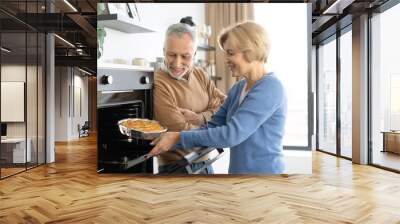 Middle aged couple baking apple pie together Wall mural