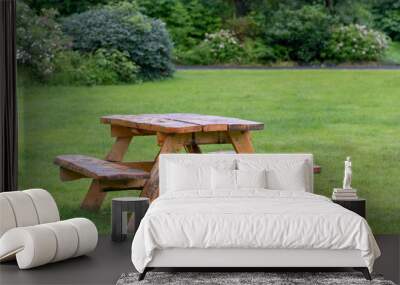 Picnic table with benches on green grass Wall mural