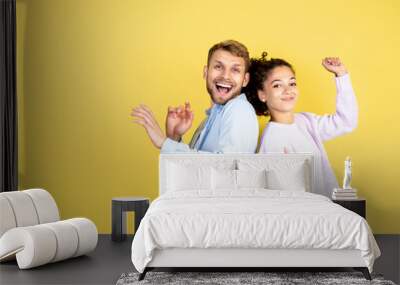 Two mixed race people on yellow background Wall mural