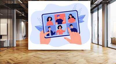 Female hand holding tablet with group video call isolated flat vector illustration. Cartoon digital tablet with online conference on screen. Virtual community and communication concept Wall mural