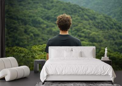 person standing on top of the mountain, a man wearing a plain black t-shirt, forest background, person looking out from the window, camper, hiking Wall mural