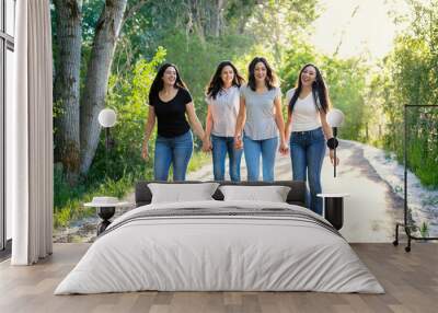 A group of beautiful young Hispanic women walking together outdoors. Candid photo of young adults having fun Wall mural