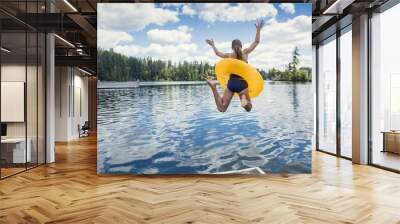 A little girl jumping off the dock into a beautiful mountain lake. Having fun on a summer vacation Wall mural