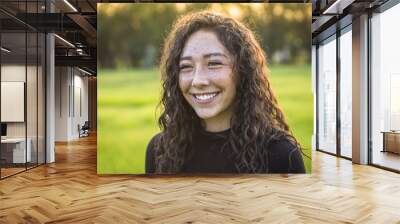 Candid photo of beautiful Hispanic teen girl outdoors. Cute and smiling young woman with brown hair laughing and having fun Wall mural