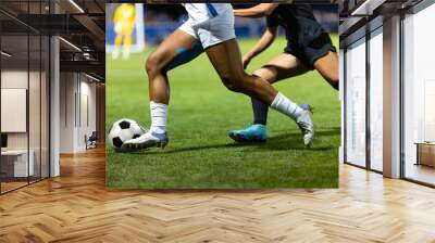 Close up action photo of two soccer players competing in a soccer game. Offensive player trying to score and dribble the ball towards goal. Wall mural