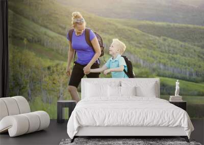 family hiking in the mountains. a young mother and her son take a hike together in the mountains on  Wall mural