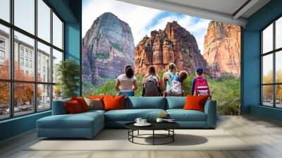 Family looking up at the amazing rock formations at Zion National Park in Utah. A diverse group of children and adults enjoying nature and admiring the Majestic rock cliffs Wall mural