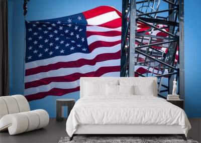 A construction site crane flying a United States Flag in the background with a clear blue sky on a bright sunny day Wall mural