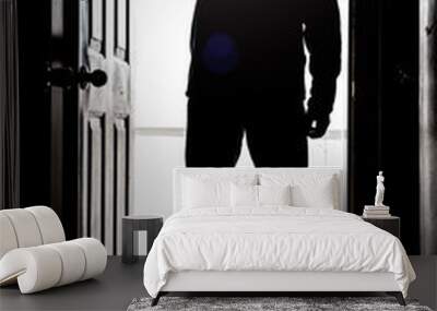 Man standing at door, in silhouette with flashlight Wall mural