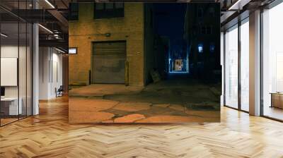 Dark city street corner and alley with an industrial building entrance at night Wall mural