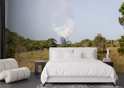 Peak summit of the friar of Angra dos reis coming out of smoke, seen from the city of Bananau in the Serra da Bocaina in Sao Paulo. Wall mural