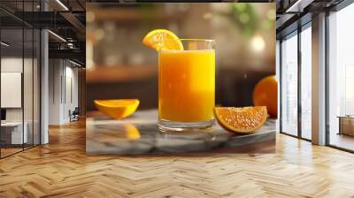 A refreshing glass of orange juice garnished with a slice, surrounded by fresh oranges on a marble surface. Wall mural