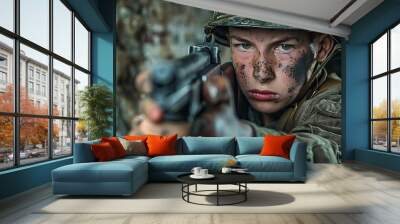 A young soldier aiming a weapon, showcasing determination and intensity in a gritty environment. Wall mural