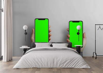 Two hands holding smartphones with green screens, ready for digital content creation. Wall mural