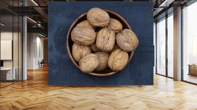 broken walnuts and nutcracker on black background Wall mural