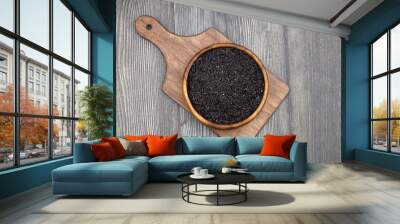 pile of black rice in a wooden bowl on a wooden table close-up Wall mural