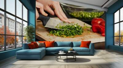 Unknown human hands cooking in kitchen. Woman is busy with vegetable salad. Healthy meal and vegetarian food concept. Wall mural