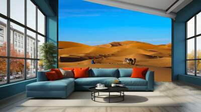 Morocco. Merzouga. A muslim wadi pray in a sand dunes of Sahara desert under a blue sky Wall mural