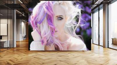 close-up portrait of a beautiful sexy young blonde girl hipster with lilac and pink hair on the background of blooming lilacs, posing Wall mural