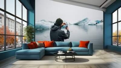 Big screen and high resolution futuristic, immersive technology smartphone, man makes photo or video of beautiful nordic landscape, ice cold ocean with floating icebergs and glaciers Wall mural