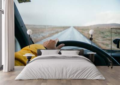 Female hand hold steering wheel of old camper van on empty mountain road. Open horizons and endless possibilities, road trip concept. Camper van conversion  Wall mural