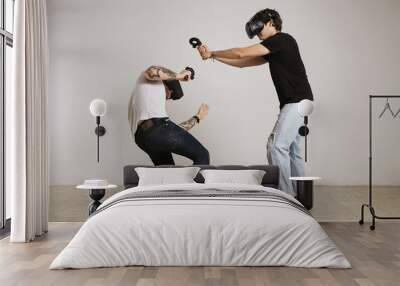 Two young men in VR headsets fight, the man in black t-shirt hits and the man in white t-shirt ducks and blocks Wall mural