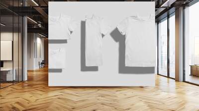 Unlabeled white shortsleeve cotton t-shirt folded in three different ways and lying flat on white background Wall mural